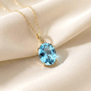 Radiant 14K Yellow Gold Necklace with 6 Carat Oval Blue Topaz Pendant.