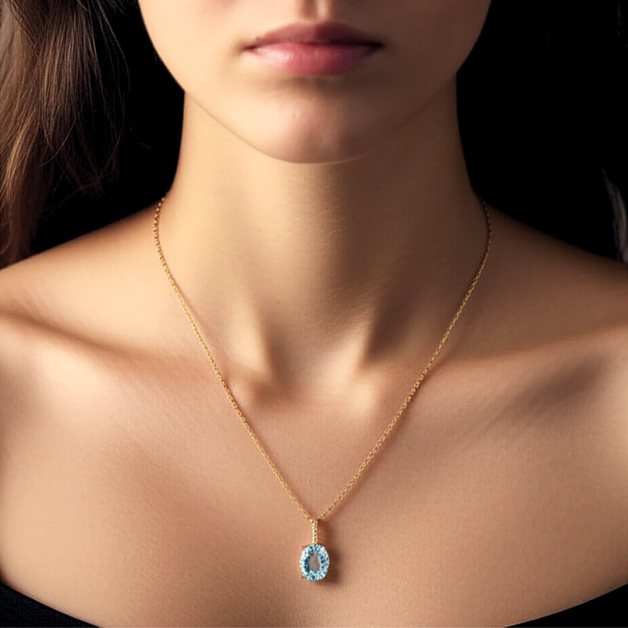 Radiant 14K Yellow Gold Necklace with 6 Carat Oval Blue Topaz Pendant.