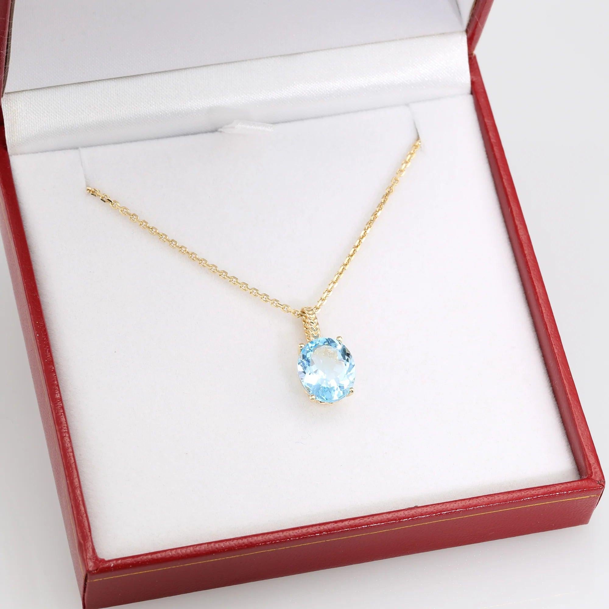 Radiant 14K Yellow Gold Necklace with 6 Carat Oval Blue Topaz Pendant.